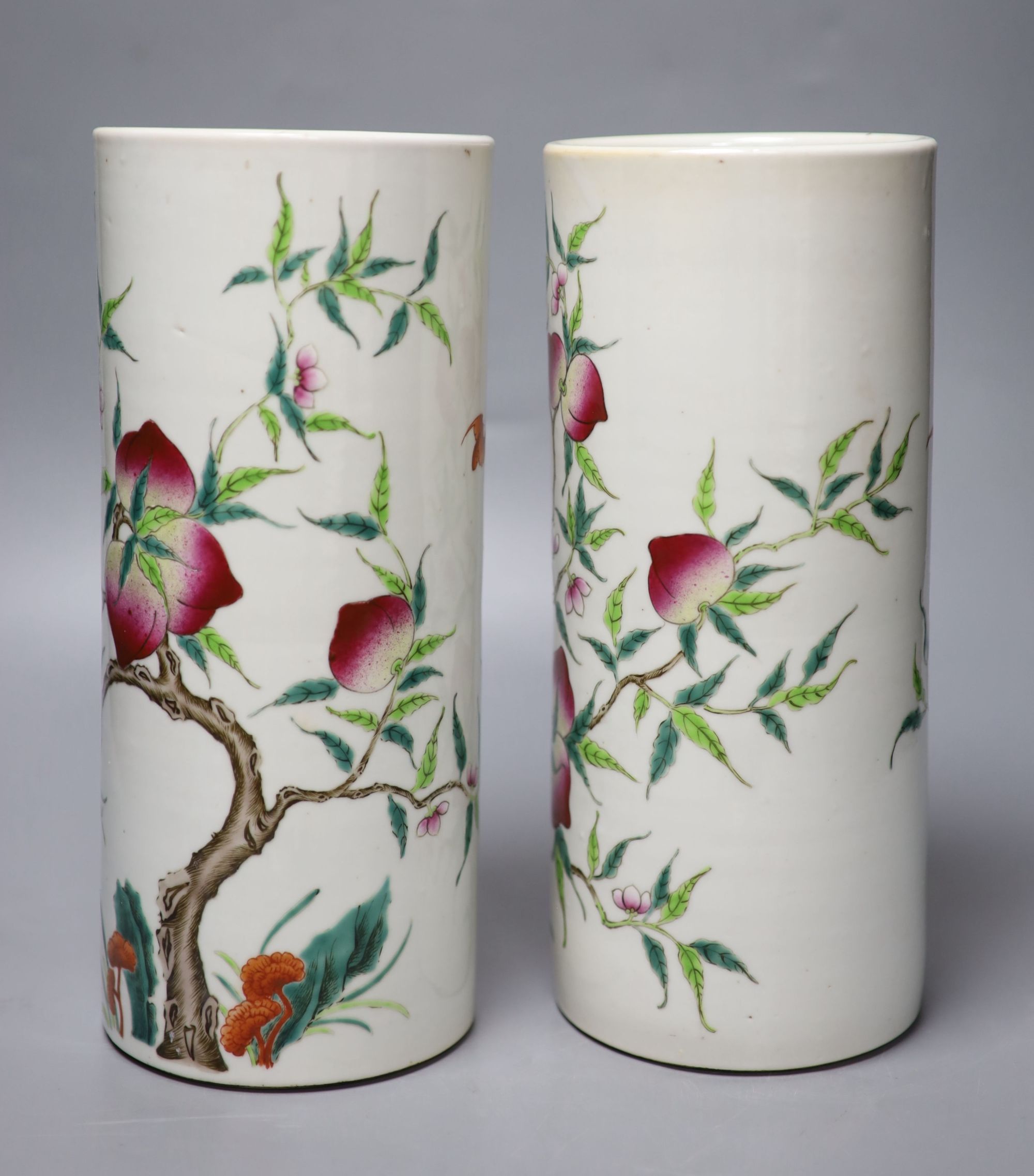 A pair of Chinese famille rose nine peach cylindrical vases, height 28cm